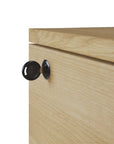A close-up of a black key in the lock of the Ethnicraft Billy Drawer Unit - Oak, highlighting the lock and key details.