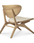 The Eye Lounge Chair by Ethnicraft features a solid oak frame, curved backrest, angled legs, and an off white cushioned seat—offering minimalist comfort and ergonomic style inspired by modern design.