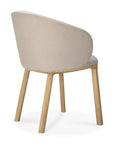 The Ethnicraft Unda Dining Chair features light wood legs and a curved, upholstered beige shell backrest and seat, shown at an angle to highlight its elegant back and side design.