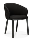 The Unda Dining Chair by Ethnicraft features a modern black upholstered shell, curved backrest, and wooden legs, inspired by Studio Segers’ design—shown against a white background.