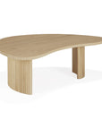 The Ethnicraft Boomerang Coffee Table - Oak is a modern solid oak piece with a smooth, organic-shaped top and two distinct asymmetrical legs—one solid, one with vertical slats—shown on a white background.
