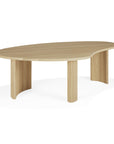 The Boomerang Coffee Table - Oak by Ethnicraft features a light solid oak build with an asymmetrical, organic-shaped top and three fluted legs, offering a modern minimalist look inspired by classic European design. Shown against a plain white background.