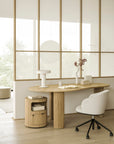 A light-colored, oval wooden Ethnicraft desk with fluted legs, paired with an Unda Office Chair and a matching cylindrical side cabinet.