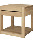 The Azur Nightstand by Ethnicraft is a square wooden side table made from European oak with a hardwax oil finish, featuring a single drawer and open shelf in a simple, modern design with clean lines inspired by Ethnicraft style.