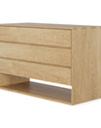 The Ethnicraft Nordic Dresser, crafted in solid European oak with a natural finish, features three wide drawers and an open shelf at the bottom. Shown against a white background.