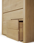 A close-up of the Ethnicraft Shadow Dresser shows its solid oak construction and minimalist design, with one drawer partially open and clean lines highlighting its modern style.
