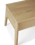 A close-up of the Ethnicraft Air Nightstand, featuring simple, clean lines and angled legs in oak, shown on a white background—an elegant piece inspired by Ethnicraft furniture.