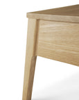 Close-up of the Air Nightstand by Ethnicraft, highlighting its light wood leg with smooth, clean lines and a natural finish—exemplifying the brand’s timeless style—set against a white background.