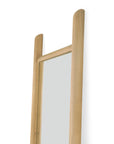 A close-up of the Ethnicraft PI Floor Mirror - Oak, showing its rectangular solid oak frame with two rounded vertical posts extending above the top edge. The wood has a light, natural polished finish against a plain white background.