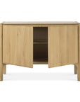 The Ethnicraft Pi Sideboard - 2 door features a minimalist modern design in solid oak with rounded edges, four legs, and two partially open doors revealing empty storage. Finished in protective hardwax oil.