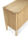 A close-up of the Ethnicraft Pi Sideboard - 3 door, crafted in solid oak with rounded corners and legs, and finished in smooth, light natural wood.