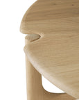 Close-up of the Ethnicraft Pi Side Table - Oak, showcasing its rounded edges and distinctive interlocking leg-to-tabletop design in solid oak.