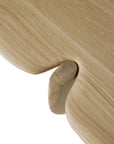 Close-up of the Ethnicraft PI Coffee Table in solid oak, featuring a smooth, rounded joint where two pieces interlock seamlessly, highlighting the natural grain and soft edges.