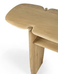 The PI Console - Oak by Ethnicraft features a smooth, organic solid oak top, rounded edges, sculptural legs, a single lower shelf, and a light natural finish.