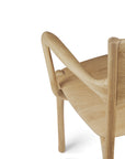 A close-up of the Ethnicraft PI Dining Chair - Oak with arms, featuring a curved backrest and smooth natural finish, crafted from solid oak and shown isolated against a white background.