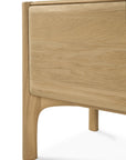 Close-up of the corner of Ethnicrafts PI TV Cupboard, highlighting its solid oak build with rounded edges, smooth modern legs, and striking natural wood grain.
