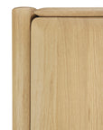 Close-up of the Ethnicraft PI Cupboard - Oak, featuring smooth, rounded corners and edges that highlight its natural wood grain and minimalist design—a refined piece of handcrafted storage furniture.