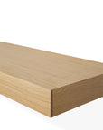 A close-up of the corner of the Ethnicraft Wall Shelf - Oak, featuring a light European oak finish, displayed against a plain white background.