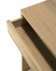 A close-up of the Ethnicraft Wave Desk - Oak features an open drawer, highlighting its clean, modern design that combines classic European style with natural oak grain and straight edges for a timeless appeal.