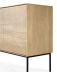 The Ethnicraft Whitebird Sideboard - 3 door features solid oak construction with light natural wood grain, flat front panels, and slim black metal legs, shown here against a white background.