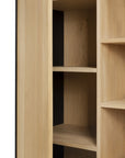 A close-up of the Blackbird Storage Cupboard by Ethnicraft, featuring light European oak shelves with smooth surfaces, rectangular compartments, and clean lines.