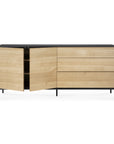 The Ethnicraft Blackbird Sideboard features a light European oak finish, black top and legs, two doors with spacious shelves on the left, and three drawers on the right for ample storage.