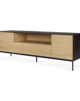 The Ethnicraft Blackbird TV Cupboard features a black frame, light European oak drawers, open central shelf, clean lines, four legs, and a sleek minimalist design.