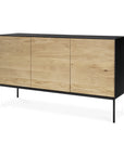 The Ethnicraft Blackbird Sideboard - 3 door features minimalist, contemporary design with three European oak doors, a sleek black frame, and slim black metal legs.