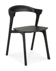 The Bok Dining Chair - Black Oak by Ethnicraft is a modern, minimalist chair with a curved backrest, angled legs, flat seat, and an open space between the backrest and seat.