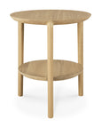 The Bok Side Table - Oak by Ethnicraft is a round solid oak side table with three legs, a lower circular shelf, and a simple, modern design inspired by the Bok side table collection.