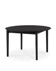 The Ethnicraft Bok Round Extendable Dining Table in black solid oak features four straight legs and a modern design, displayed against a plain white background.