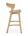 Side view of the Bok Counter Stool by Ethnicraft, a modern light solid oak stool with a curved backrest and footrest, showcasing clean lines and minimalist design, shown against a white background.