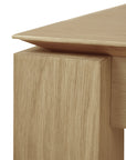 Close-up of the Slice Dining Table - Oak by Ethnicraft, highlighting its solid oak tabletop, thick leg, clean modern lines, and visible wood grain.