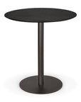 The Ethnicraft Blend Dining Table - Black Oak features a round black oak top and a central metal pedestal base with a circular platform, showcasing minimalist, modern design inspired by Ethnicraft's signature style.