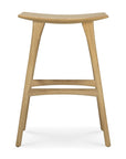 The Ethnicraft Osso Barstool - Oak features a minimalist design with a curved seat, four straight legs, and dual support bars. Crafted from solid oak with a natural light finish, it embodies modern European style for an elegant look.