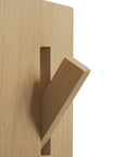 A close-up of the Ethnicraft Utilitile Wall Hanger shows a light wood panel with a rectangular slot and angled peg, emphasizing its minimalist, modern design.
