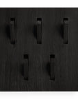 The Utilitile Wall Hanger by Ethnicraft features a square black panel with six angled rectangular hooks. Its matte finish and grain lines reflect Ethnicraft’s minimalistic design.