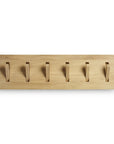 The Utilitile Wall Hanger by Ethnicraft features a minimalistic design with six foldable hooks, evenly spaced on a solid oak rectangular base, perfect for wall mounting.