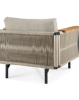 The Ethnicraft Corbey Outdoor Lounge Chair showcases a woven rope back, taupe cushion, black metal legs, and wooden armrests—ideal for outdoor relaxation. Displayed from the rear on a white background.