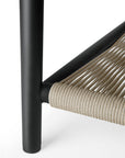 Close-up of a black metal chair leg with tightly woven beige rope seat, set against a white background—perfectly paired with the Ethnicraft Corbey Outdoor Coffee Table.