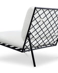 The Salma Outdoor Lounge Chair by Moes features a black metal frame, open lattice back, angled legs, and white Olefin fabric cushions with quick-dry foam in a minimalist geometric design.