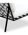 Close-up of the Salma Outdoor Lounge Chair by Moes, showcasing its black metal frame with a grid-patterned back and thick white quick-dry foam cushions for lasting comfort.