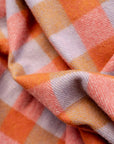 Close-up of the FAIRE/TBCo Recycled Wool Blanket in Orange Gingham, featuring a soft woven texture and subtle wrinkles that highlight its drape.