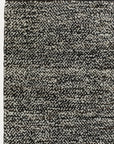 Close-up of the Armadillo&Co Acacia Rug - Sable, showcasing its hand-knotted texture, black, white, and gray speckled pattern with a dark edge and distinctive salt-and-pepper look.