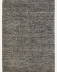 The Acacia Rug - Sable by Armadillo&Co features a rectangular, woven texture with a mottled black, gray, and white speckled look. This Fair Trade rug offers a simple, modern design with no border or central motif.