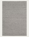 The Sherpa Rug - Pumice by Armadillo&Co is a rectangular, handwoven gray wool rug featuring a subtle woven texture, shown against a plain white background.