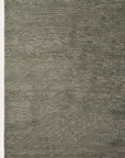 The Corsica Rug - Agave by Armadillo&Co features muted green and gray tones, a subtle horizontal texture, and a simple fringe. This hand-knotted wool rug is soft and understated—ideal for modern or minimalist spaces.