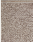 A close-up of the Palus Rug - Anise by Armadillo&Co shows its beige textured wool and bound edge against a white background—an elegant example of sustainable design.