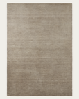 The Thatch Rug - Concrete by Armadillo&Co is a large, rectangular wool rug featuring a subtle beige and light brown gradient on a plain background, designed for comfort and durability.