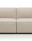 The Baker Sofa | Fabric by Wooden Stories is a modern, light beige Danish sofa with clean lines, wide armrests, and a low backrest, offering supportive comfort against a plain white background.